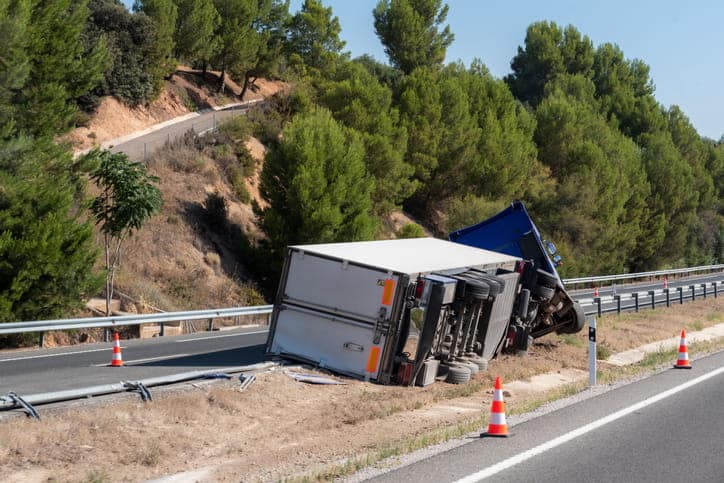 Miami Accidentes De Camiones 7 Camión De Carga Blanco Y Azul Volcado Junto A La Valla De Seguridad En Una Carretera Con Conos De Tráfico.