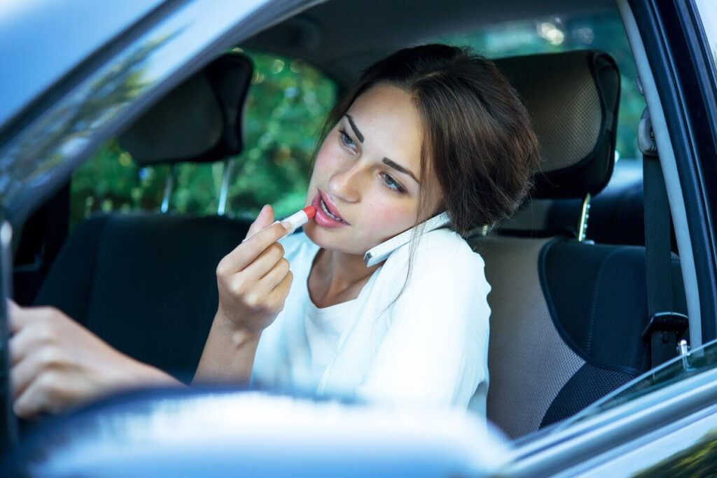 Woman applying lipstick while driiving