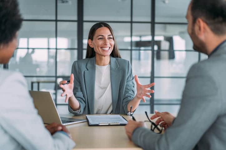 A personal injury lawyer smiling with two of her clients. 