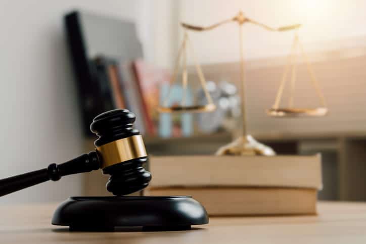 A gavel, a stack of books and the scales of justice on a slip-and-fall injury attorney's desk. 