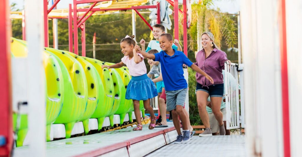 group of kids getting on theme park ride