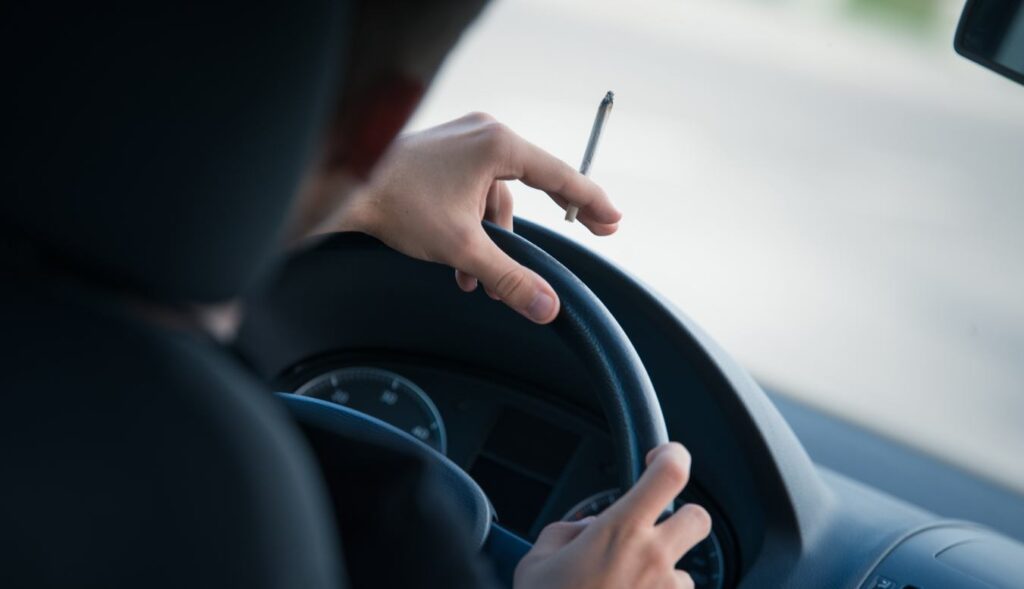 Man driving and smoking joint