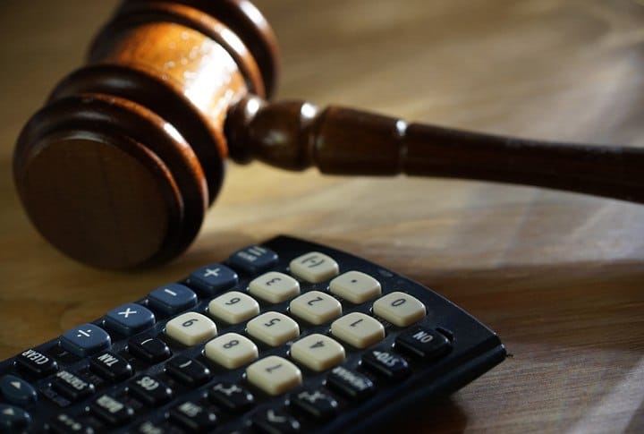 Judge's gavel and calculator on desk