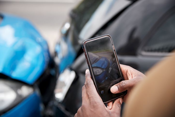 person taking photos of damage of car accidents