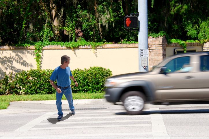 pedestrian about to be hit by a pickup truck while crossing the street