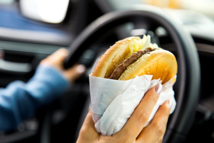 woman driving and eating with one hand
