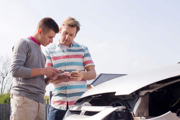 two men exchanging insurance information after an accident