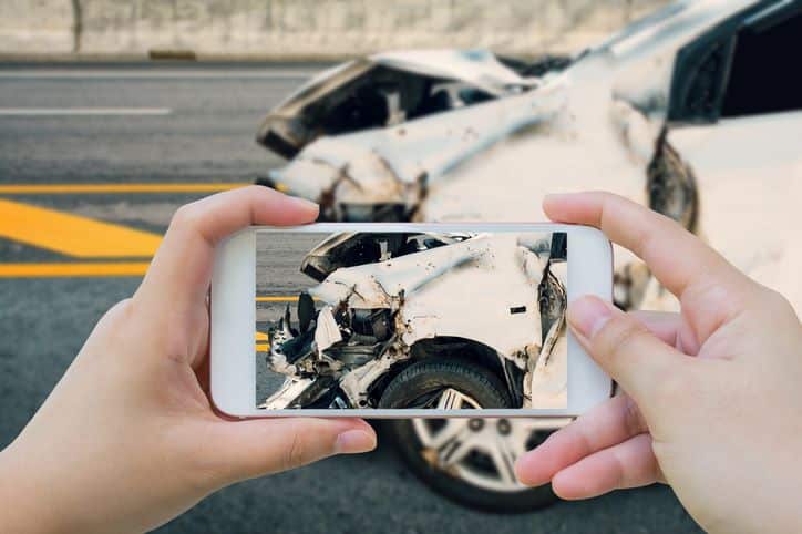 woman taking photos of car accident