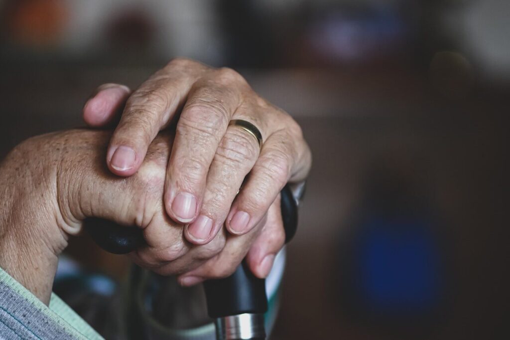 Elderly person's hands on cane