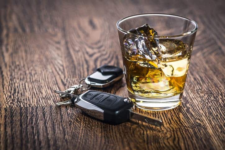 glass of alcohol near car keys