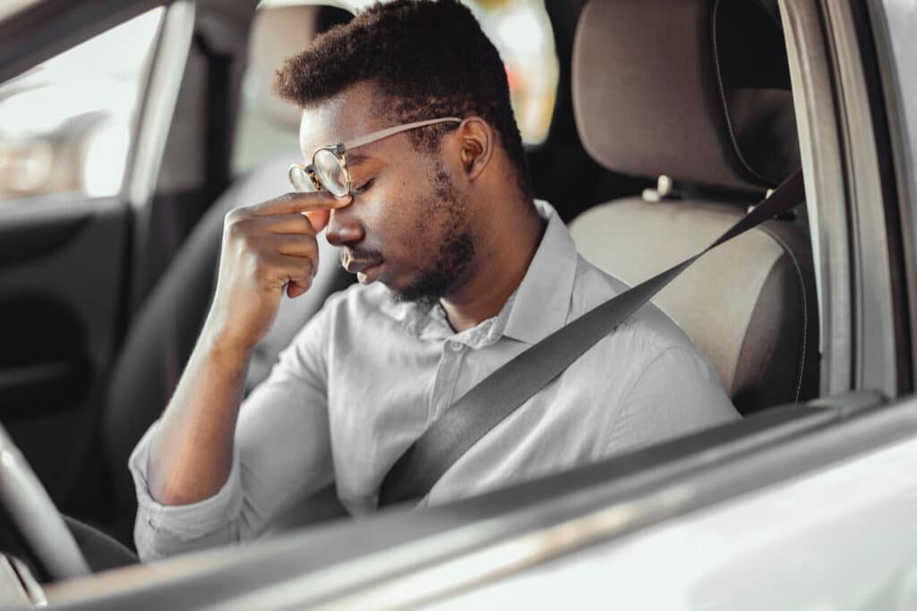 Tired driver rubbing eyes to stay awake