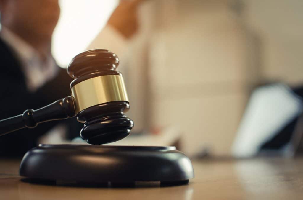 Judge in courtroom behind close up of gavel.