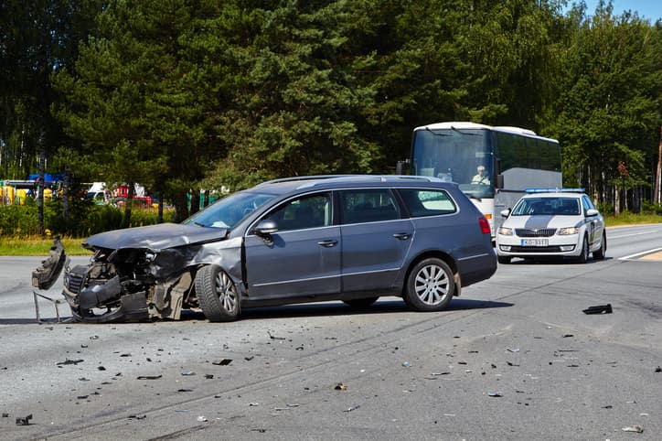 Blue station wagon with smashed front end after auto accident.