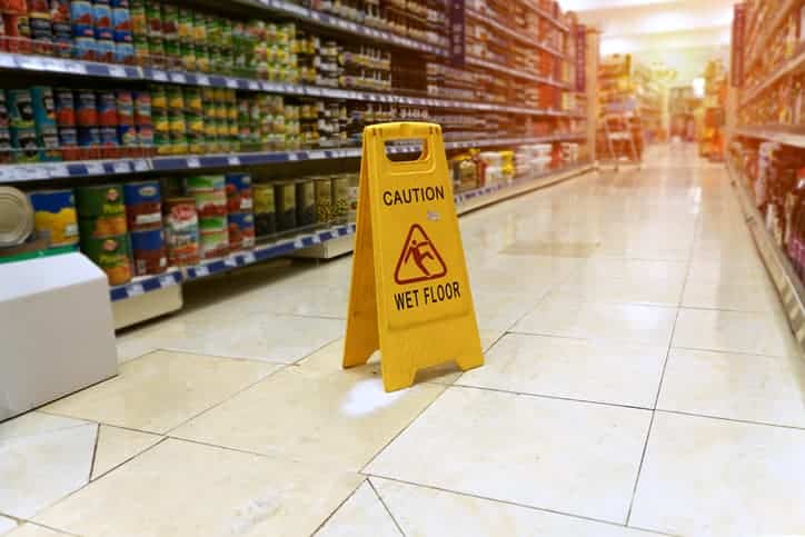 Caution wet floor sign in grocery store aisle