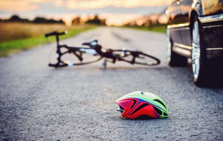 bike and helmet on road near car after crash