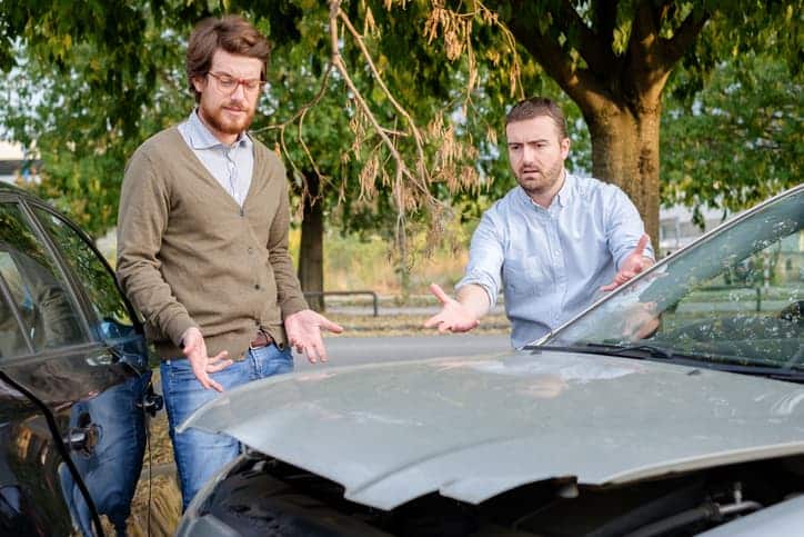 two men talking near car accident 