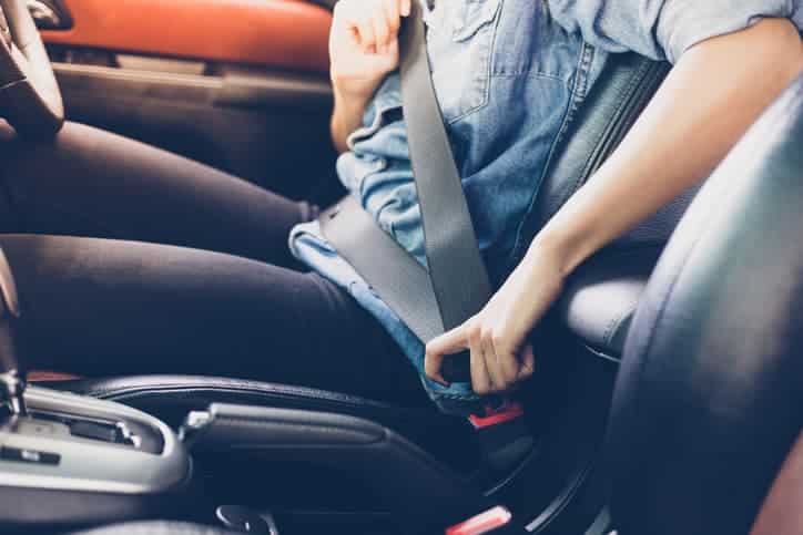 passenger in car buckling seatbelt