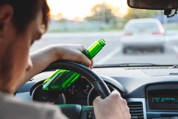 man driving with open beer bottle