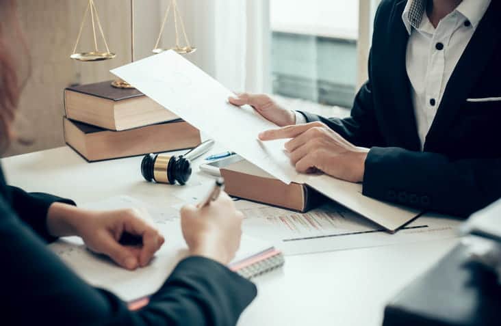 focus is on a lawyer showing their client paperwork after a car accident