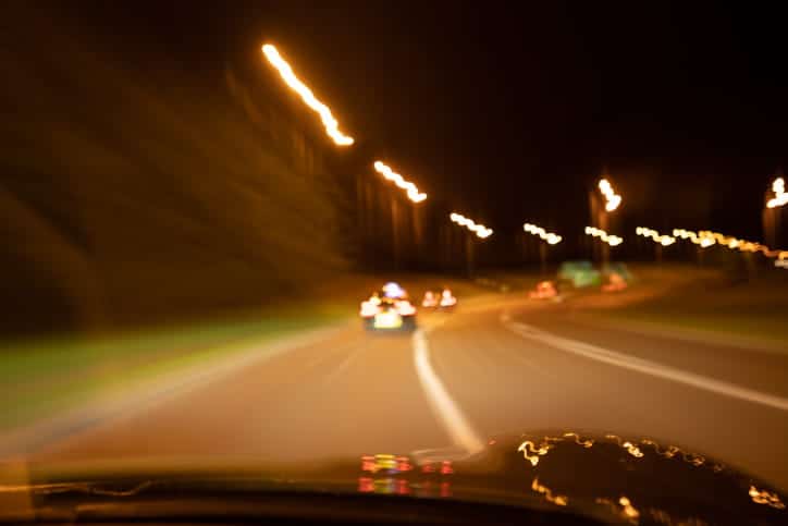 A driver's view when drunk driving. The other car lights are blurred and the photo is out of focus.