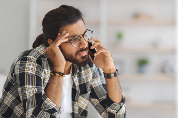 A man on the phone, dealing with auto insurance company.