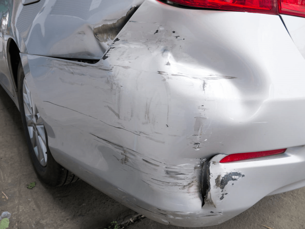 Damage to the back end of a gray vehicle after a hit-and-run accident.