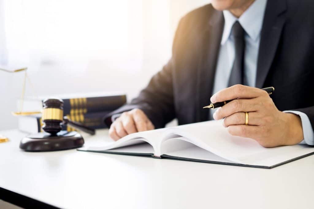 A Florida boat accident attorney working on paperwork at his desk. Next to him is a gavel and a stack of books.