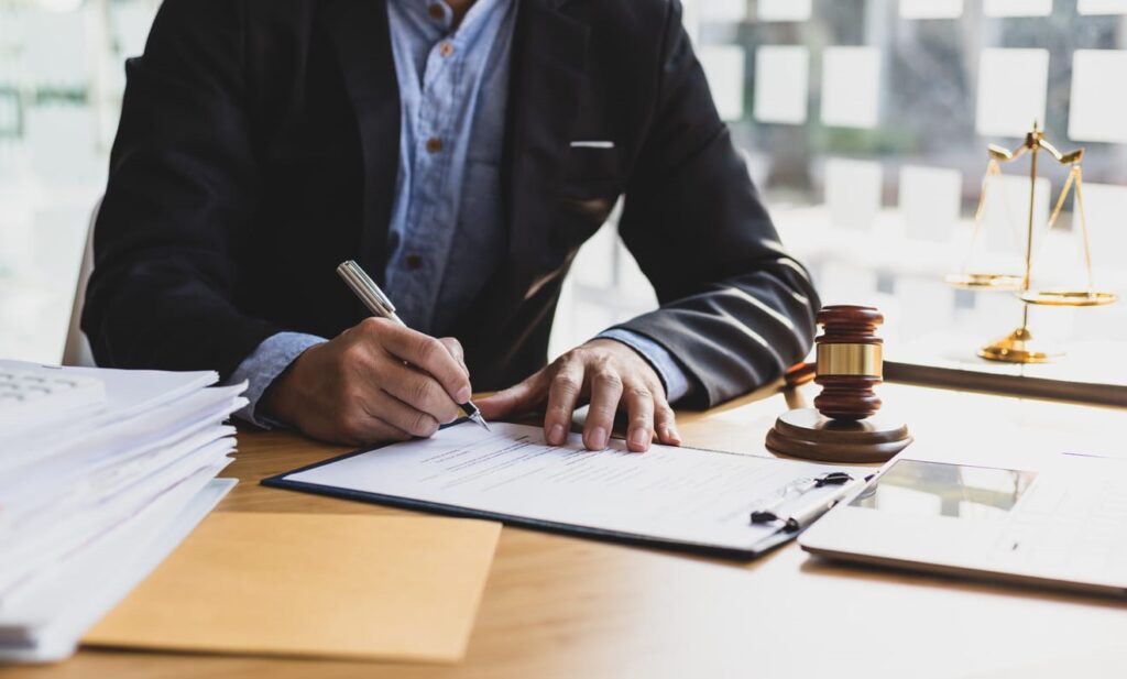 A car accident injury lawyer working on paperwork at his desk in Florida. Next to him is a gavel.