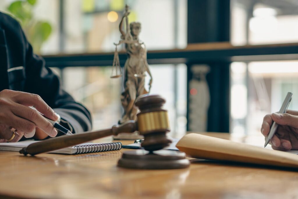 An attorneys desk with a gavel and a statue of lady justice