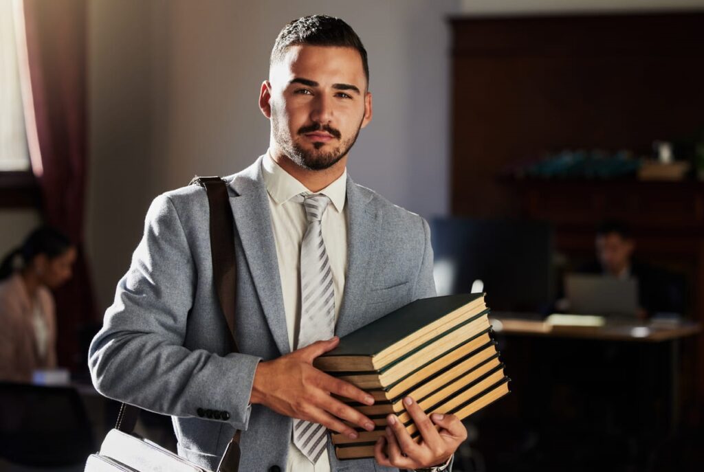 A medical malpractice attorney in Miami holding a stack of books.
