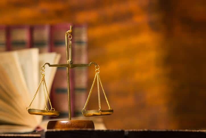 The scales of justice on a truck accident lawyer's desk. In the background are books. 