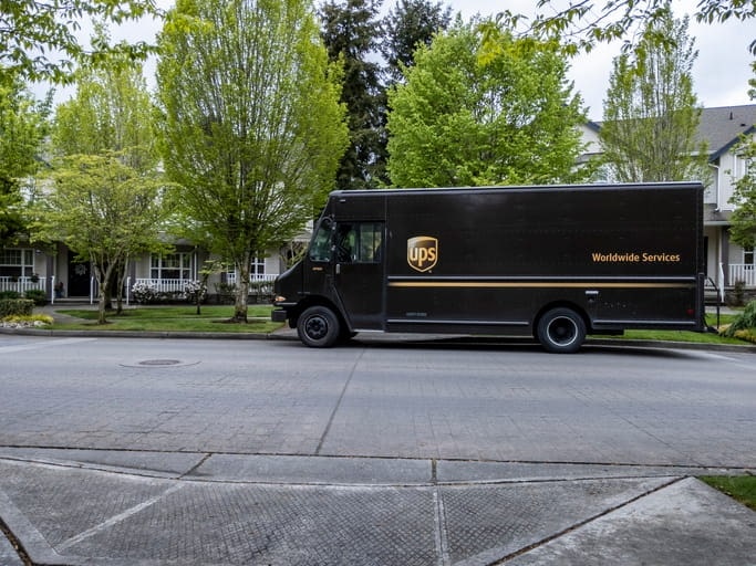 A photo of a UPS truck parked in the street. 