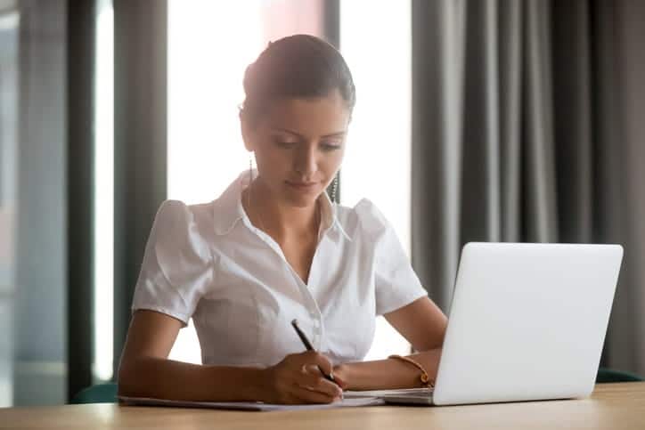 A personal injury lawyer working on her laptop at her desk in Miami, FL.