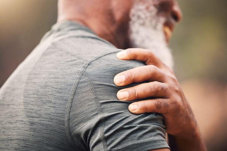 A man who suffered a personal injury accident clutching his shoulder