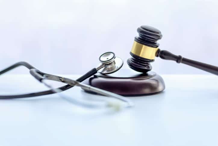 A stethoscope sitting next to a gavel. 