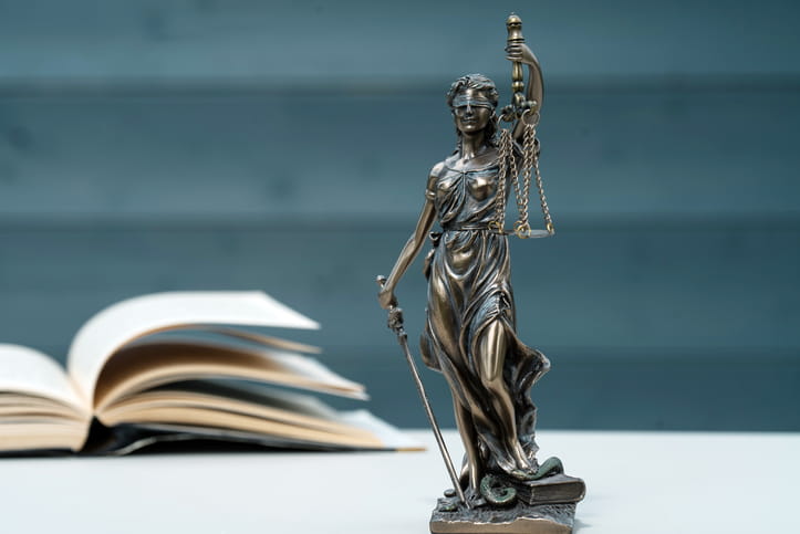 A Lady Justice statue near an open book on a personal injury lawyer's desk. 