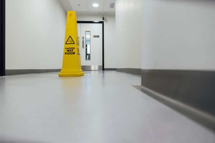 A yellow caution: wet floor sign. 