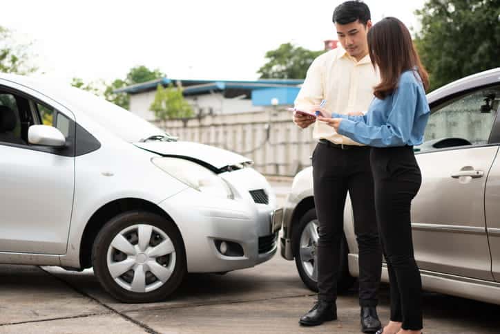Suing An Uninsured Driver For Damages 58 Two People Exchanging Information After A Car Accident.