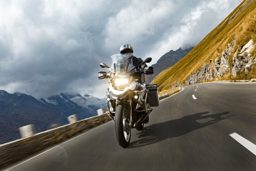 Everything You Need To Know About Florida'S Motorcycle Laws 1 Motorcycle Rider Cruising Along A Winding Highway In The Florida Mountains, Surrounded By Rocky Terrain And Cloudy Skies, Symbolizing Adventure And Freedom.