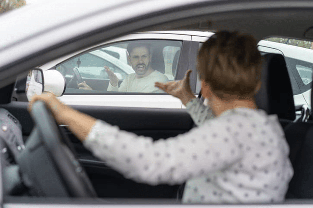 A Woman Driving A White Car Gesturing Angrily Toward A Man In Another White Car, Who Is Also Gesturing Aggressively Through His Window.