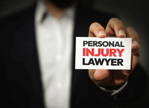 Hialeah Personal Injury Lawyer 75 A Hand Holding A White Card With The Text &Amp;Quot;Personal Injury Lawyer&Amp;Quot; In Bold Black And Red Letters, With A Person In A Suit In The Blurred Background.