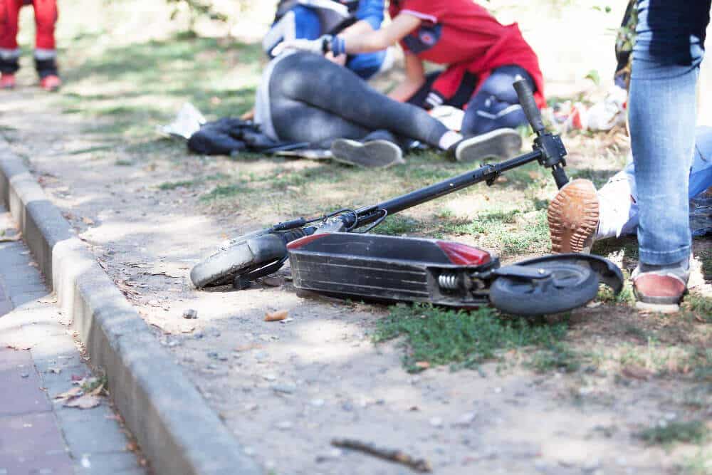 Cyclist On Roadside After Car Collision Electric Scooter Accident